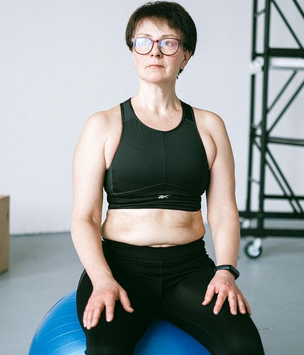 Woman performing gentle core stability exercises in a dark room
